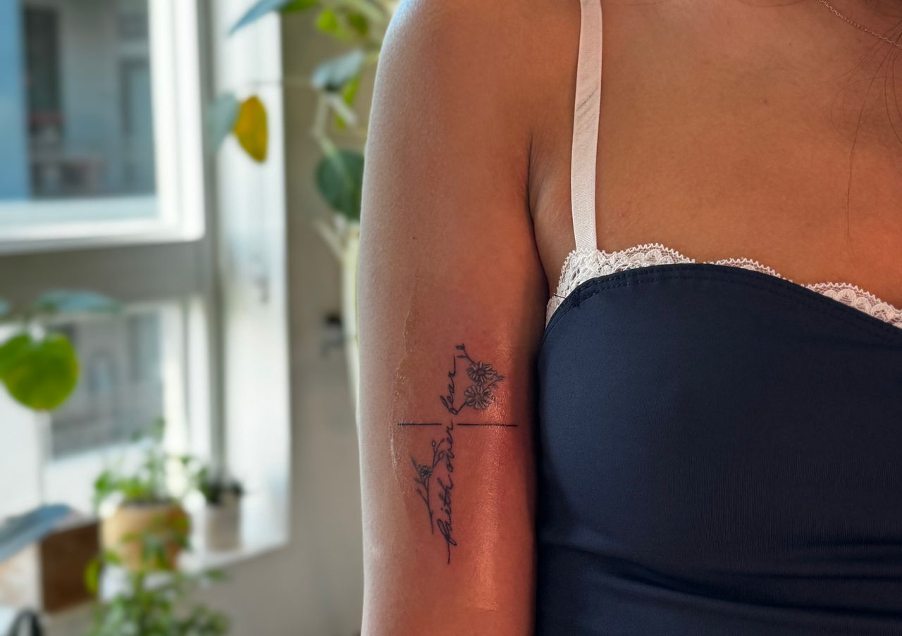 Handwritten script crossing a hairline stem with small daisies on the upper arm