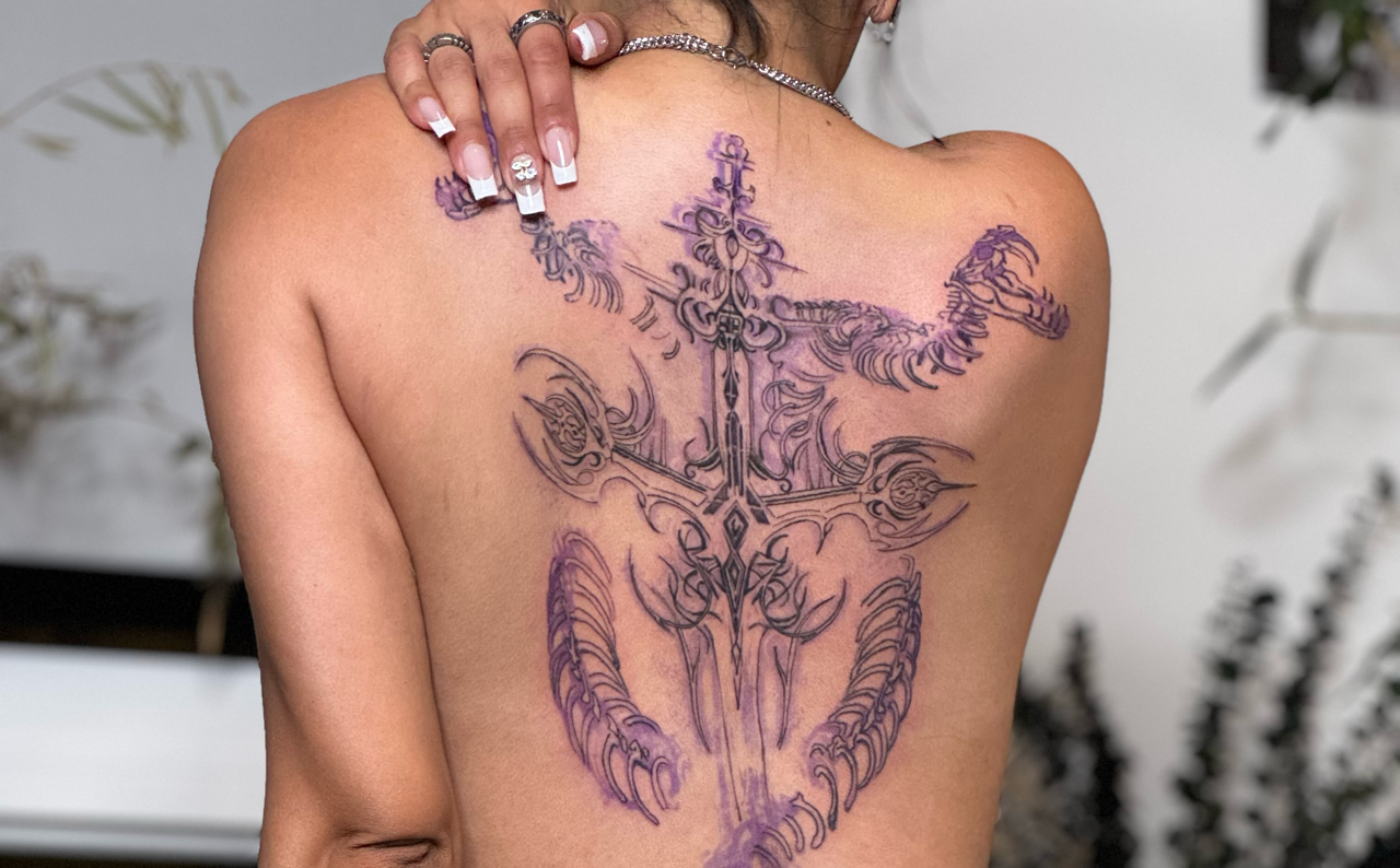 Large ornamental sword back piece with flowing flourishes across both shoulder blades